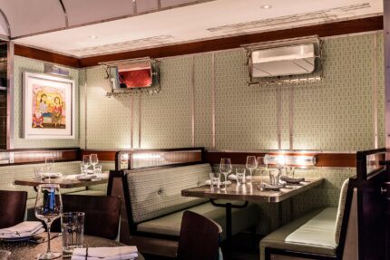 The Carriage dining area at Bombay Bustle, featuring lively sharing tables and warm decor.