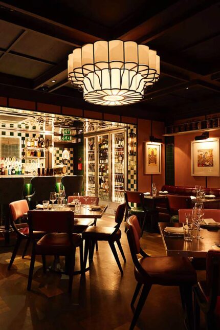 Warmly lit dining room and cocktail bar inside Bombay Bustle Indian restaurant in Mayfair.