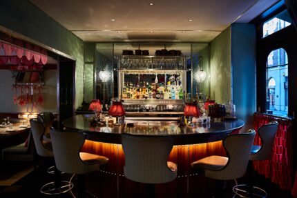 The elegant main Dining Room at Bombay Bustle, warmly lit and set for dinner service.