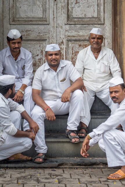 Traditional Mumbai Dabbawalas delivering tiffin boxes, the inspiration behind Bombay Bustle.